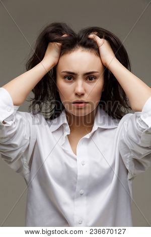 Beautiful Girl In A White Shirt Shows Emotions. On A Light Background.