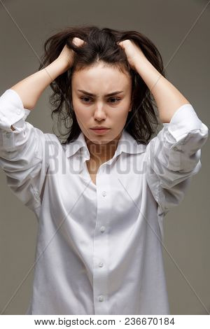 Beautiful Girl In A White Shirt Shows Emotions. On A Light Background.