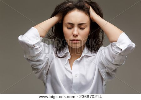 Beautiful Girl In A White Shirt Shows Emotions. On A Light Background.