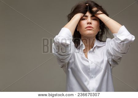 Beautiful Girl In A White Shirt Shows Emotions. On A Light Background.