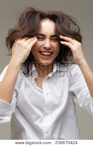 Beautiful Girl In A White Shirt Shows Emotions - Smile, Fun. On A Light Background.