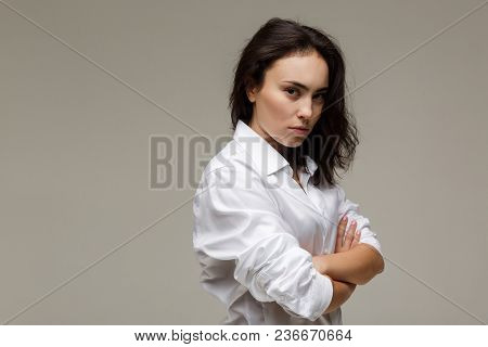 Beautiful Girl In A White Shirt Shows Emotions. On A Light Background.