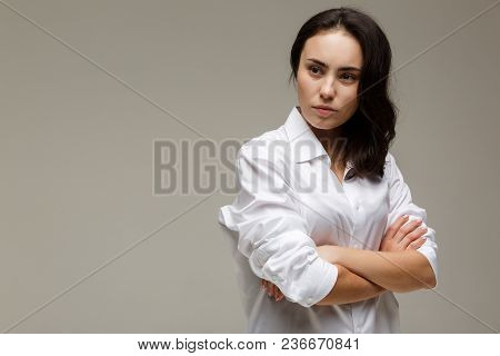 Beautiful Girl In A White Shirt Shows Emotions. On A Light Background.
