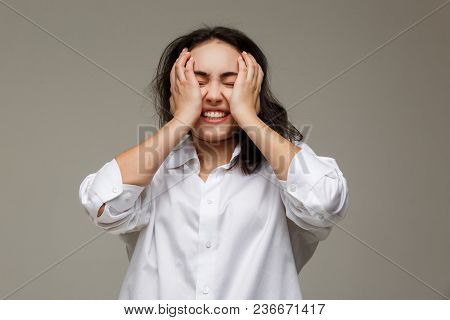 Beautiful Girl In A White Shirt Shows Emotions - Smile, Fun. On A Light Background.