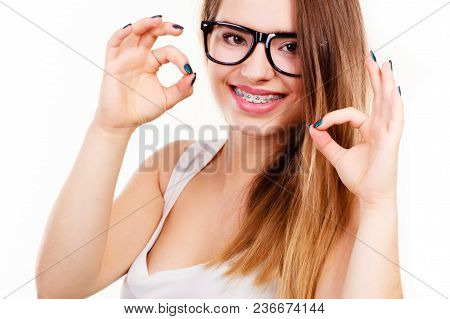 Vision And Dentistry Problems Concept. Happy Nerdy Teenage Wearing Big Eyeglasses Showing Her Braces