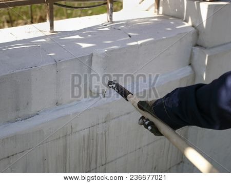 A Woker Hand Painting A Fence With Paint Roller, Outdoor Closeup