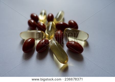 Yellow Capsules Of Fish Oil And Red Ones Of Lutein
