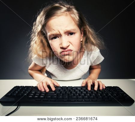 Upset child looking at a computer. Computer addiction