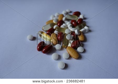 White, Red, Yellow And Orange Pills In A Heap