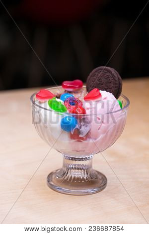 Pink ice cream croissant with biscuits and sweets