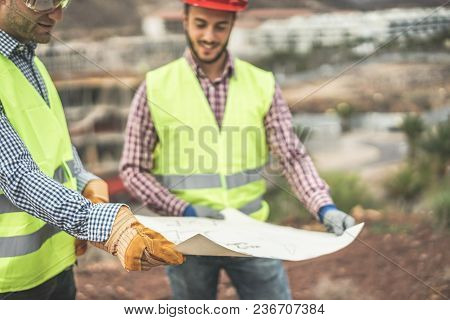 Builders On Residential Construction Site Looking The Building Project  - Workers Are Satisfied Of T