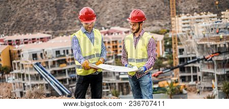 Builders On Residential Construction Site Looking The Building Project  - Workers Are Satisfied Of T