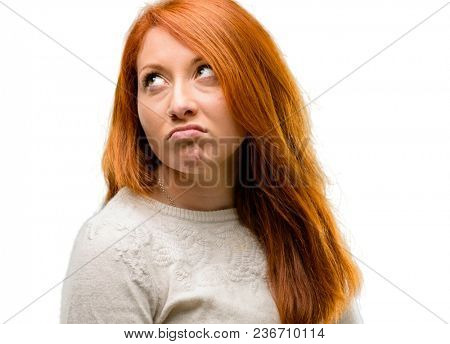 Beautiful young redhead woman making funny face fooling isolated over white background