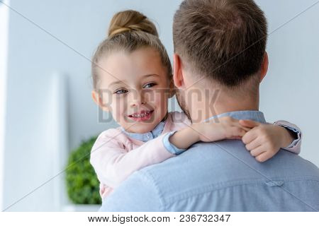 View Of Cute Preadolescent Daughter Embracing Father