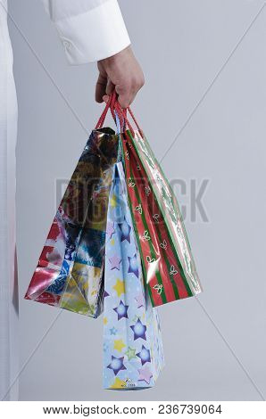 Hand Holding Shopping Bags With Gifts