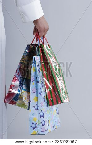 Hand Holding Shopping Bags With Gifts