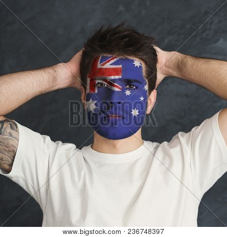 Portrait Of Frustrated Man With The Flag Of Australia Painted On His Face. Football Or Soccer Team F