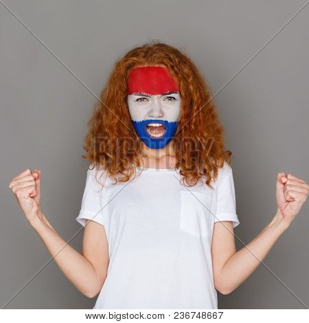 Face Of Young Screaming Woman Painted With Flag Of Holland. Football Or Soccer Team Fan, Sport Event
