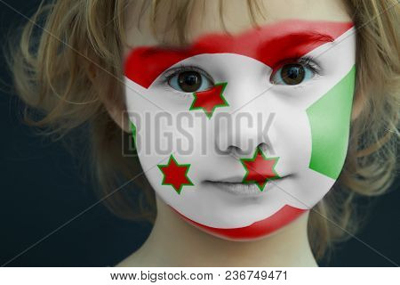 Portrait Of A Child With A Painted Flag Of Burundi On Her Face, Closeup.
