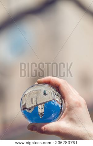 Saint Nikola Church tower reflected in a glass ball held by a tourist, Perast, Kotor harbor, Montene