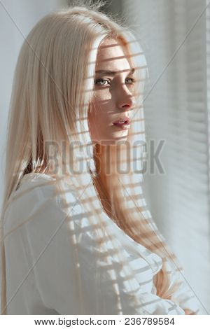 Close-up of a pensive young business woman looking out the windo