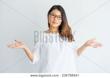 Puzzled Chinese Student Girl Shrugging Shoulders And Looking At Camera. Misunderstanding Beautiful C