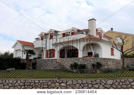 Modern Mediterranean Villa Surrounded With Traditional Stone Wall, Metal Fence, Grass, Small Vegetat