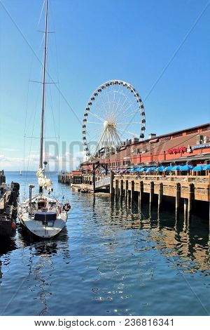 Seattle, Washington, 9/14/17, Seattle Waterfront Restaurant With A Sailboat Docked And The Great Whe