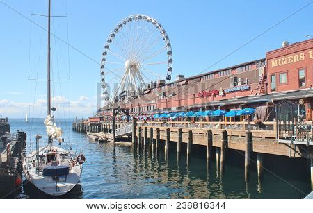 Seattle, Washington, 9/14/17, Seattle Waterfront Restaurant With A Sailboat Docked And The Great Whe