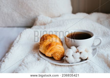 Big White Morning Cup Of Coffee And Crossant In Bed With Pillow And Cosy Blanket Decorated With Cott