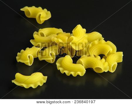 Uncooked Yellow Italian Pasta Creste Di Gallo On Dark Background Close-up