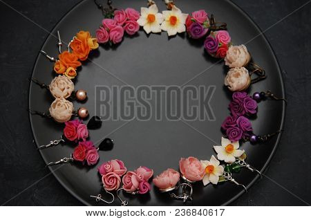 Mix Of Fake Colorful Plastic Mini Flowers Earings Black Round Plate Copy Space.