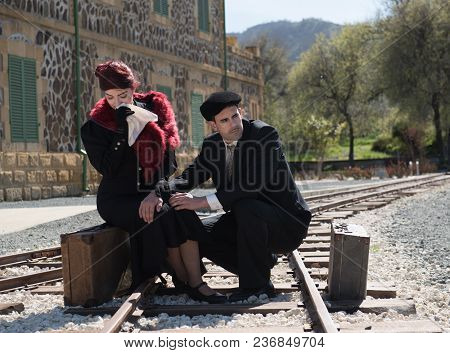 Young Couple Woman Crying And In Deep Thoughts Siting On The Trainlines Waiting For The Next Train R