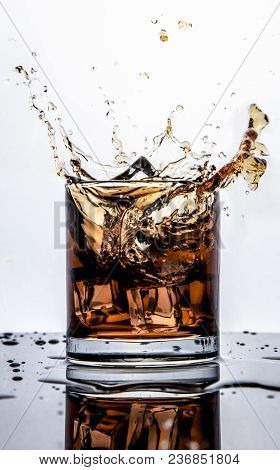 Splash Of Whiskey With Ice Isolated On White