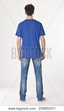 Boy In Blue T-shirt And Jeans Standing Back To Cameraman
