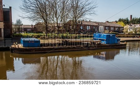 A Small Working Barge On The Canal As It Runs Through Wigan