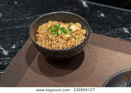 Fried Rice With Garlic And Butter And Toping With Sliced Green Onion On Traditional Cray Bowl.