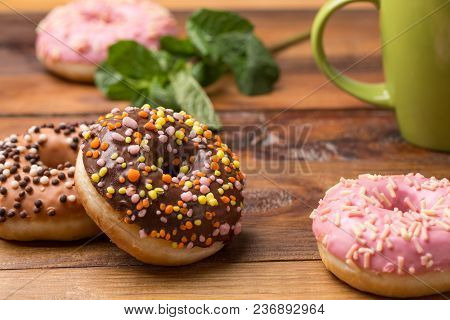 Coffee And Donut. Pink And Chokolate Donut With A Cup Of Tea On A Dark Wooden Background. Tasty Brea