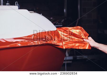 Car Wrapping Specialist Putting Vinyl Foil Or Film On Car. Selective Focus.