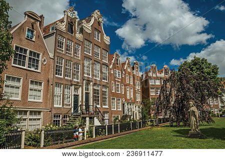 Amsterdam, Northern Netherlands - June 26, 2017. Semidetached Typical Houses And Green Garden At Beg
