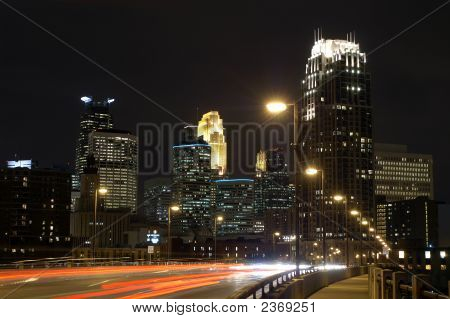 Minneapolis City Skyline om natten med broen og flytte biler