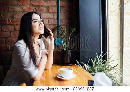 Young Charming Woman Calling With Cell Telephone While Sitting Alone In Coffee Shop During Free Time