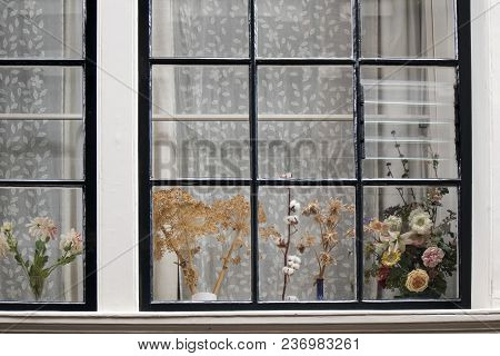 The Traditional Dutch Window With Tulle And Dry Bouquets On The Windowsill