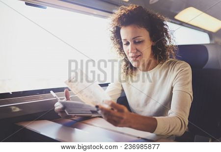 Enjoying Business Travel Concept. Young Beautiful Brunette Tourist Girl Travelling On The Train Sitt