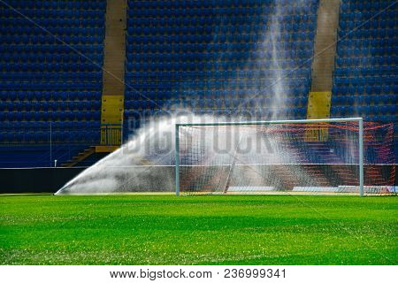 Irrigation Turf. Sprinkler Watering Football Field. System Working On Fresh Green Grass On Football