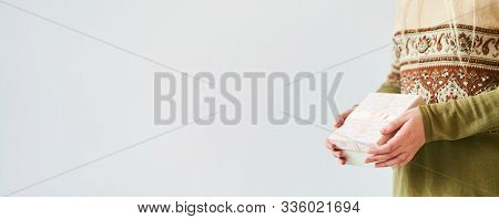 A Girl Holds A Gift Box On A White Background. Banner, Copy Space.