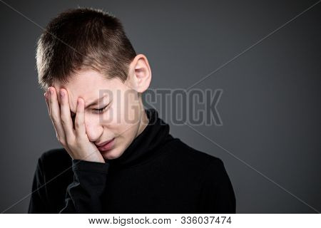 Grief-stricken little boy - feeling intense sorrow, remorse, sadnesss - studio portrait - vivid emotions series