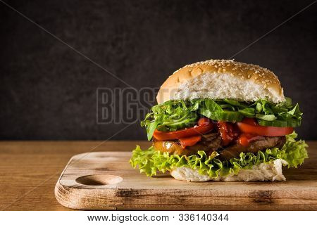 Vegan Burger With Seitan And Vegetables On Wooden Table. Fake Meat. Copy Space
