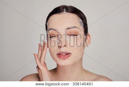Young Beautiful Tender Pritty Girl With Moisturizing Face Mask With Closed Eyes And Full Lips . Grey
