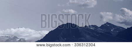 An Alpine Landscape With Mountains And Clouds